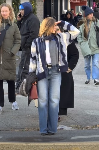 styling light bootcut jeans with a blue gradient striped sweater